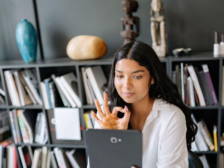 A certified Skoobon teacher smiling on a live video call with a student